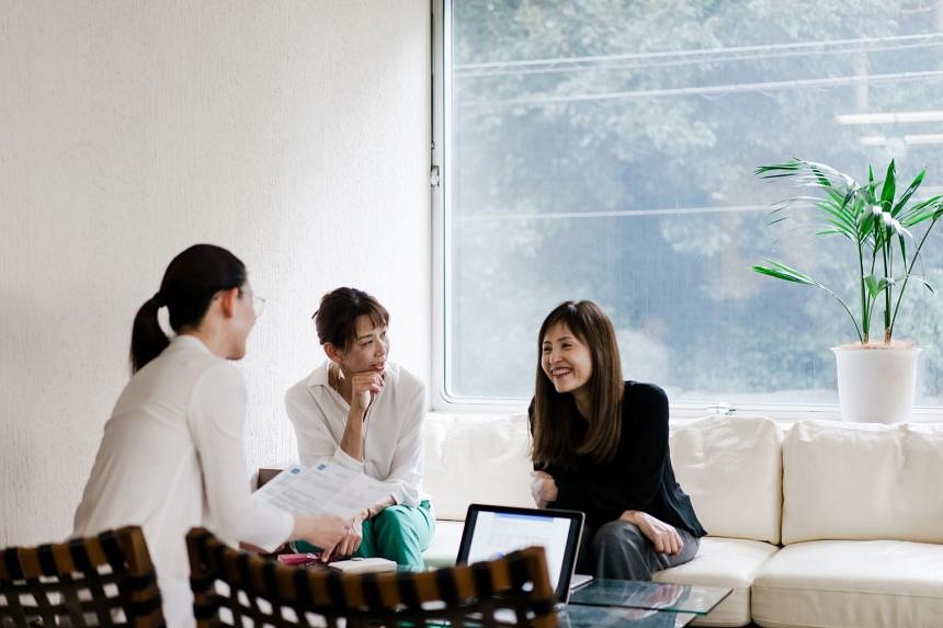 Three Asian women sitting in an office discussing